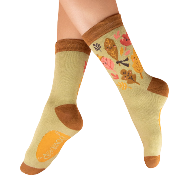 Decorative socks with autumn-themed design worn by a person on a white background