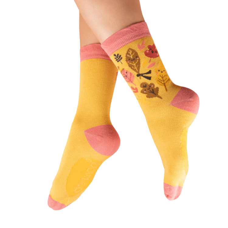 Yellow socks with pink accents and animal design worn by a person on a white background