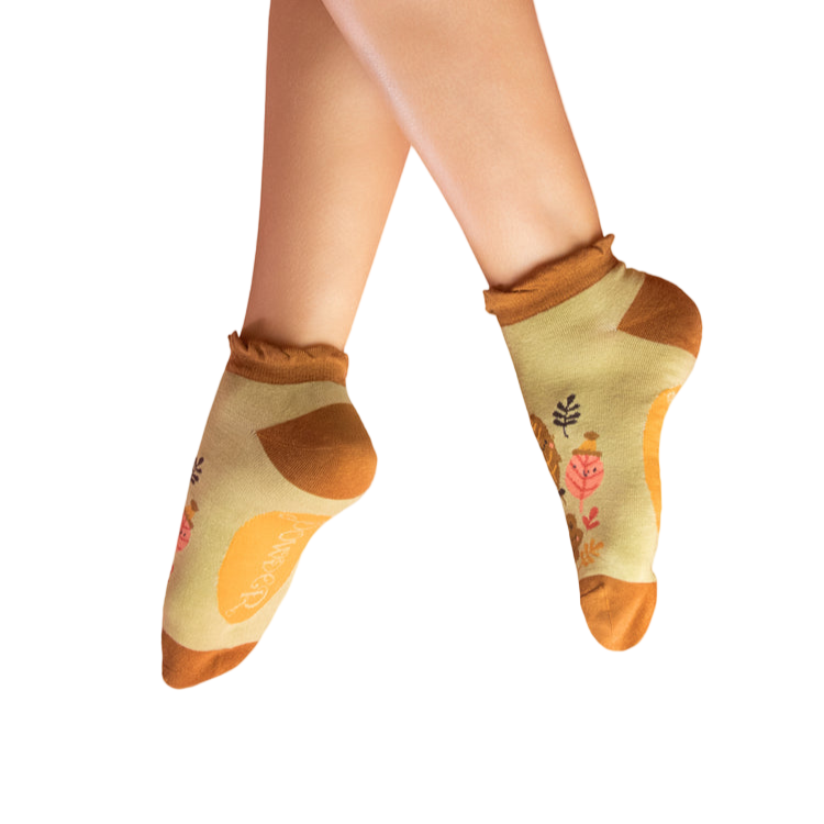 Pair of socks with leaf designs worn by a person on a white background