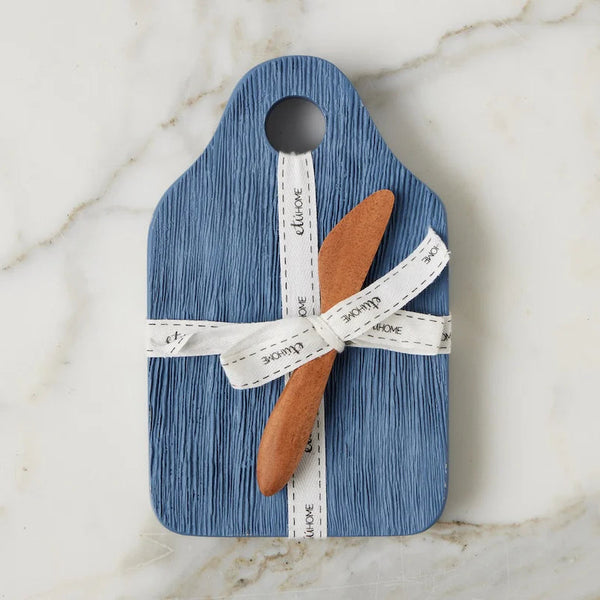 Blue cutting board with a measuring tape and wooden spatula on a marble surface
