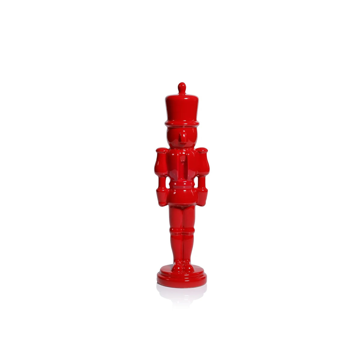 A glossy red nutcracker figurine standing upright on a white background with a soft reflection underneath.