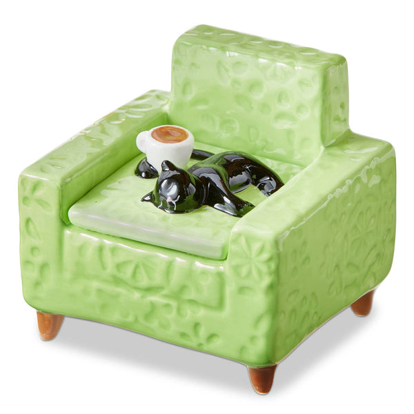 Green ceramic armchair with a small black cat and coffee mug on a white background