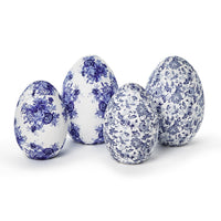 Four decorative eggs with blue floral patterns on a white background