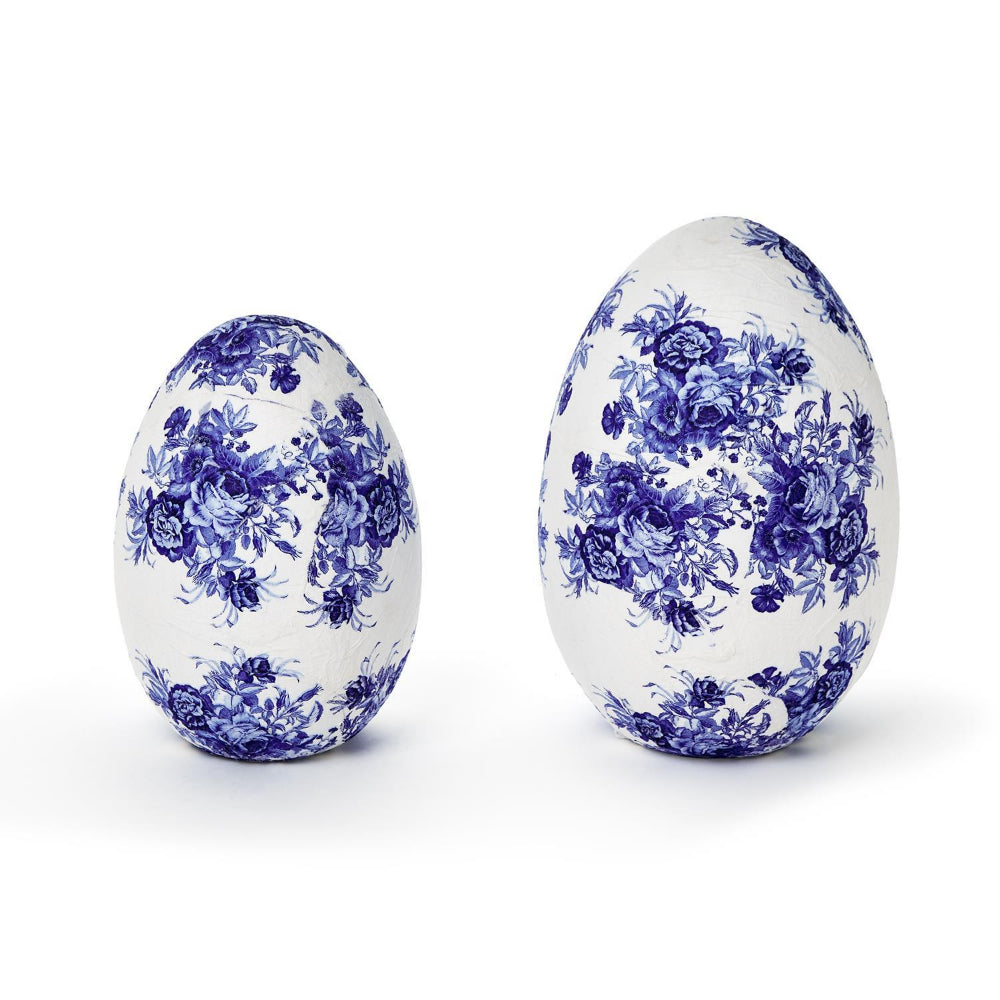 Two decorative eggs with blue floral patterns on a white background