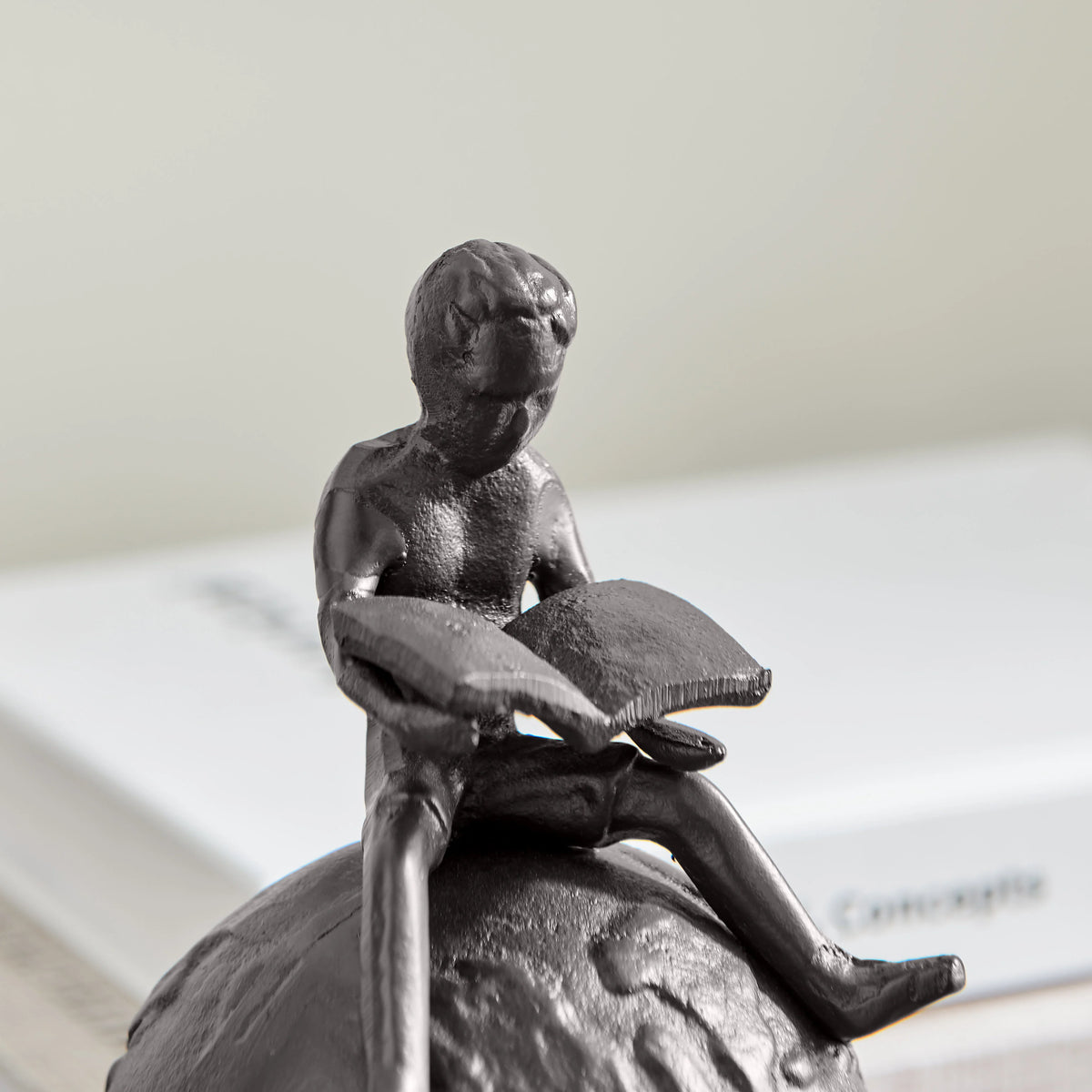 Brown Cast Iron Boy Reading on Globe Sculpture | Danya B.