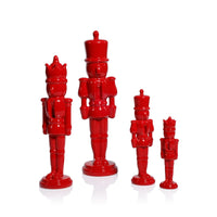 Set of red nutcracker figurines on a white background