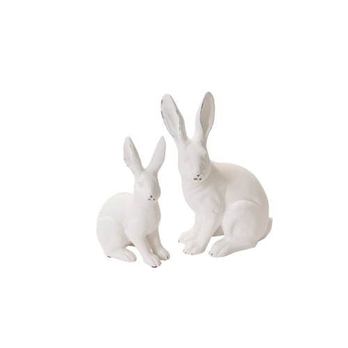 Two white ceramic rabbit figurines on a white background