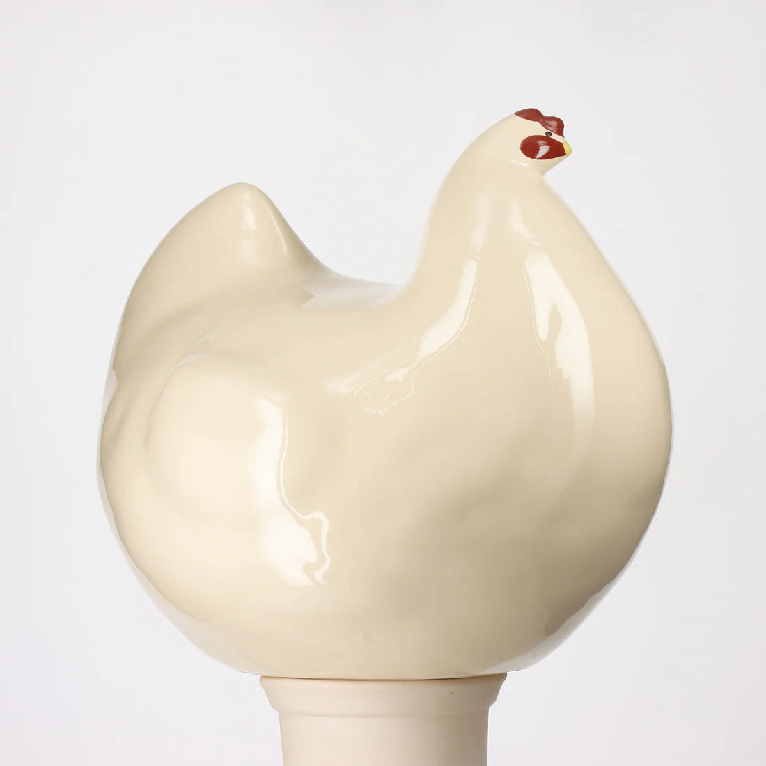 Beige ceramic chicken-shaped statue on a white background