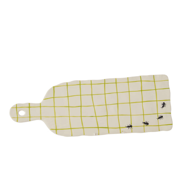 Rectangular cutting board with yellow picnic blanket pattern and black ant designs on a white background