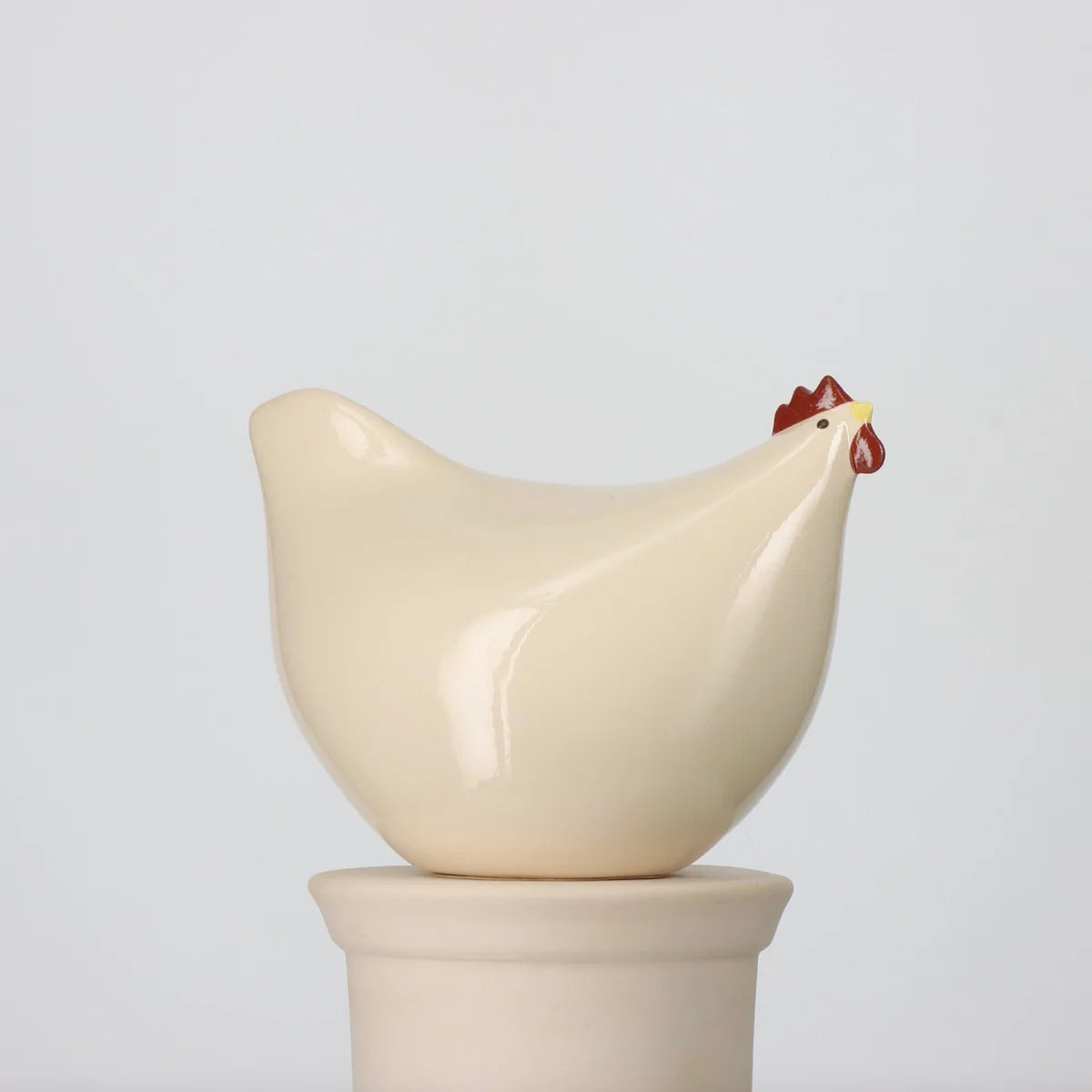 Ceramic chicken-shaped statue on a white background