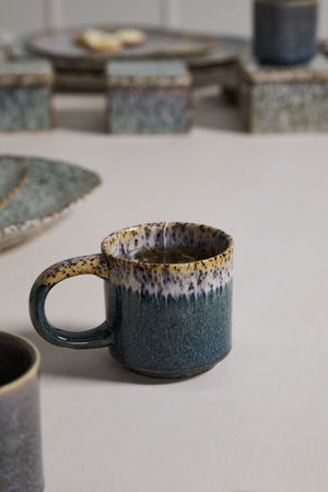 Ceramic mug with speckled design on a neutral surface