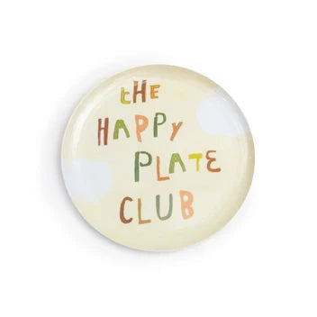 A round melamine plate featuring the text 'THE HAPPY PLATE CLUB' in a playful, multicolored hand-drawn font on a cream-colored background with faint white cloud illustrations.